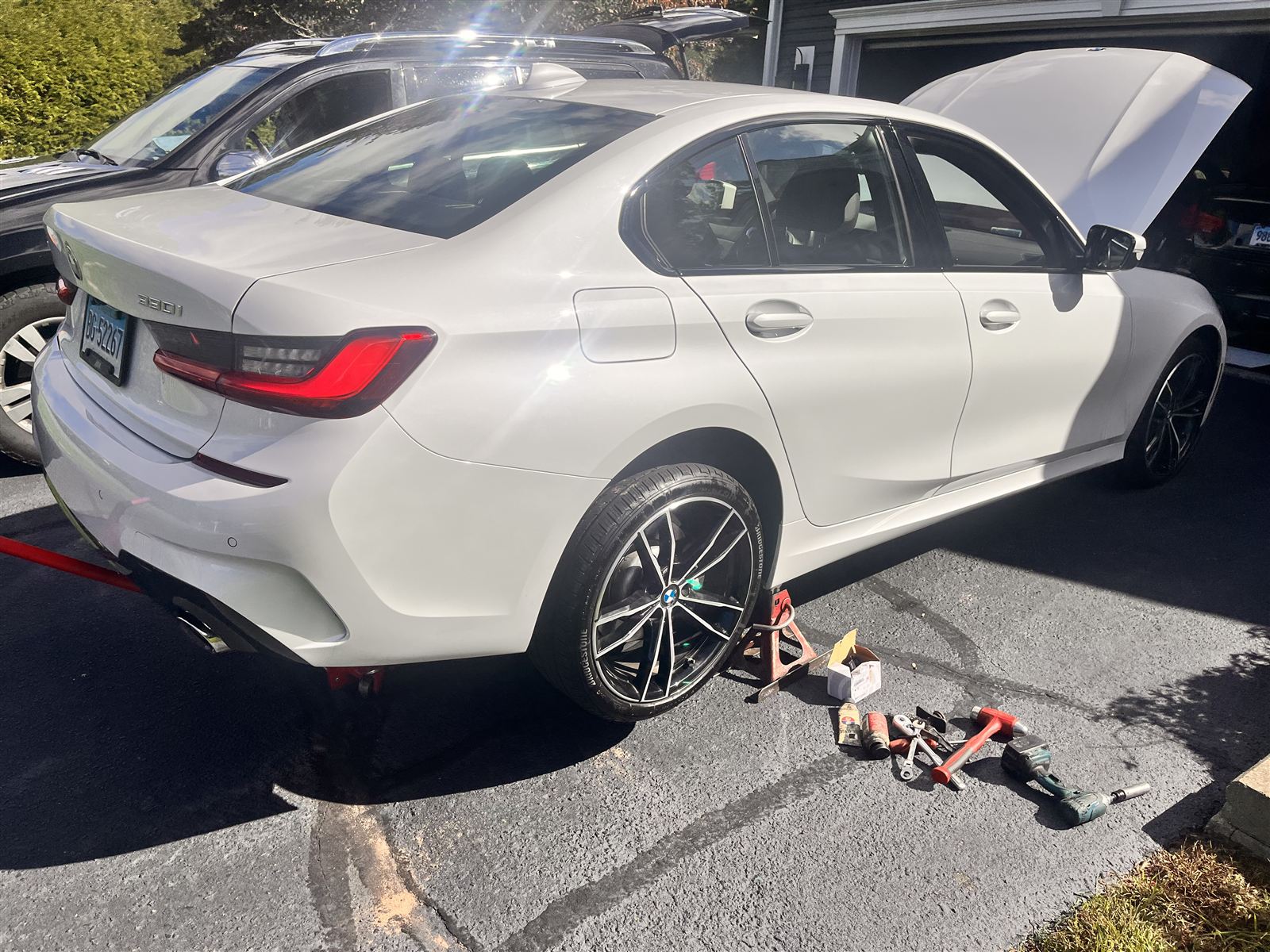 BMW 330i being serviced on location in a customer's driveway
